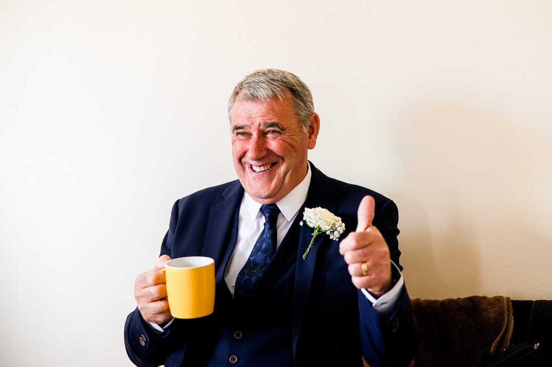 man sits with a cup of tea giving the thumbs up at Poulaphouca House