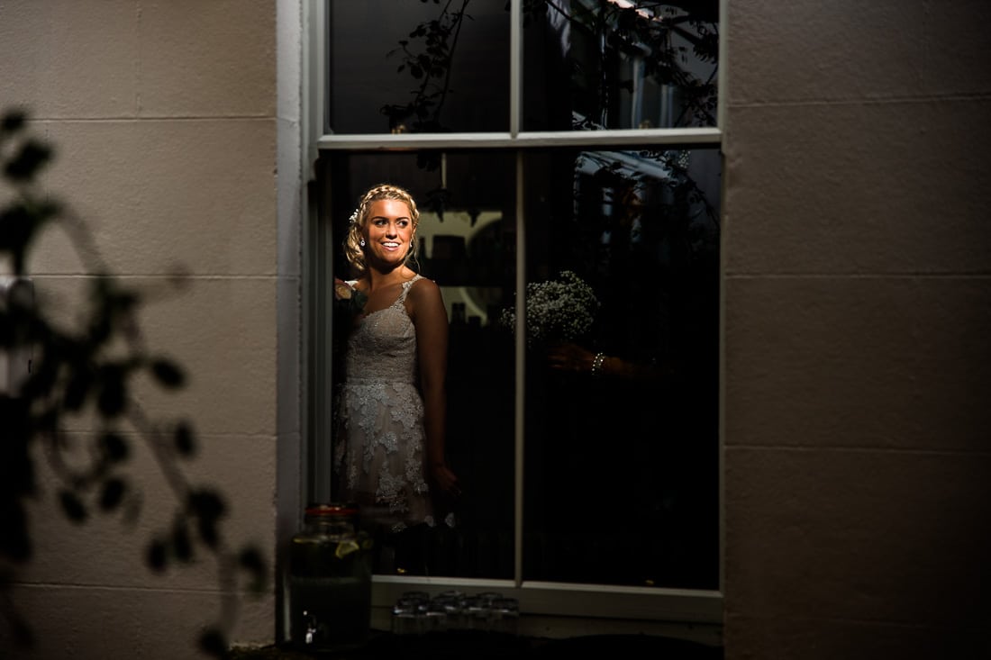 the bride looks out of a window at Poulaphouca House in wicklow