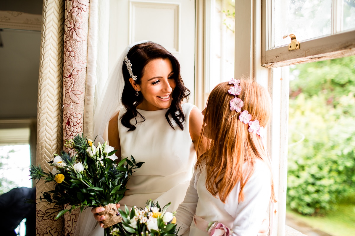a bride and her flower girl share a lovely moment at a Wedding At Ballintubbert Gardens and House