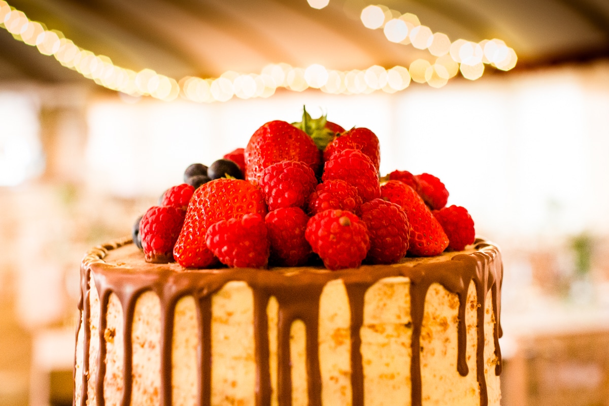a wedding cake in the marquee topped with strawberries