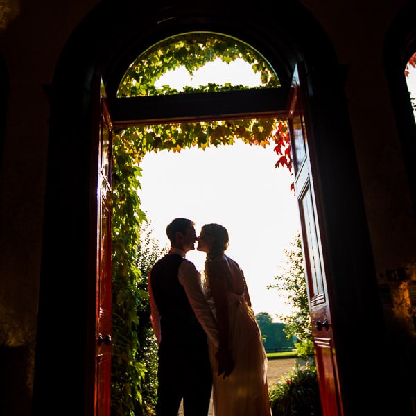 bride and groom kiss at the lyraths doorway