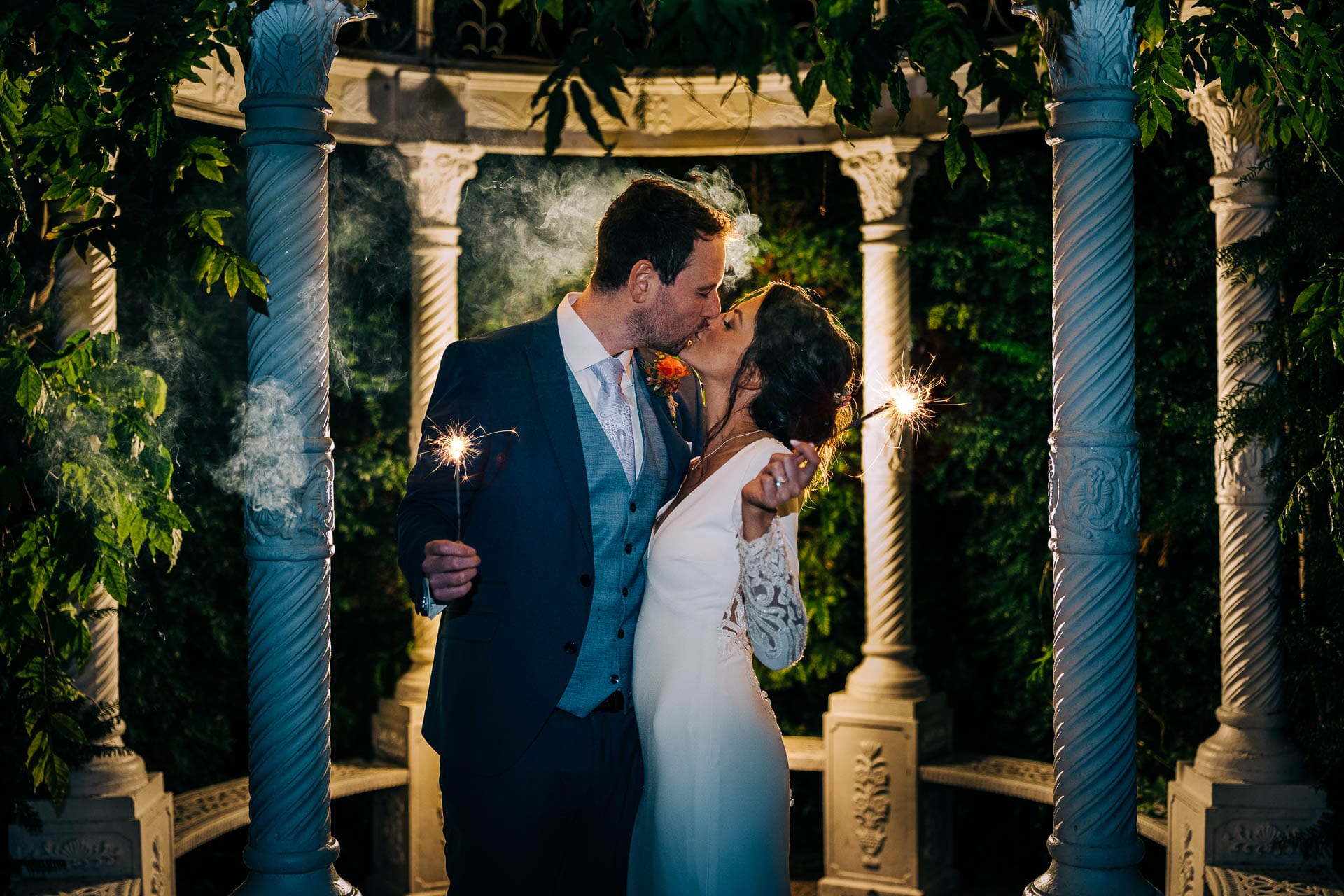 bride and groom pose with sparklers