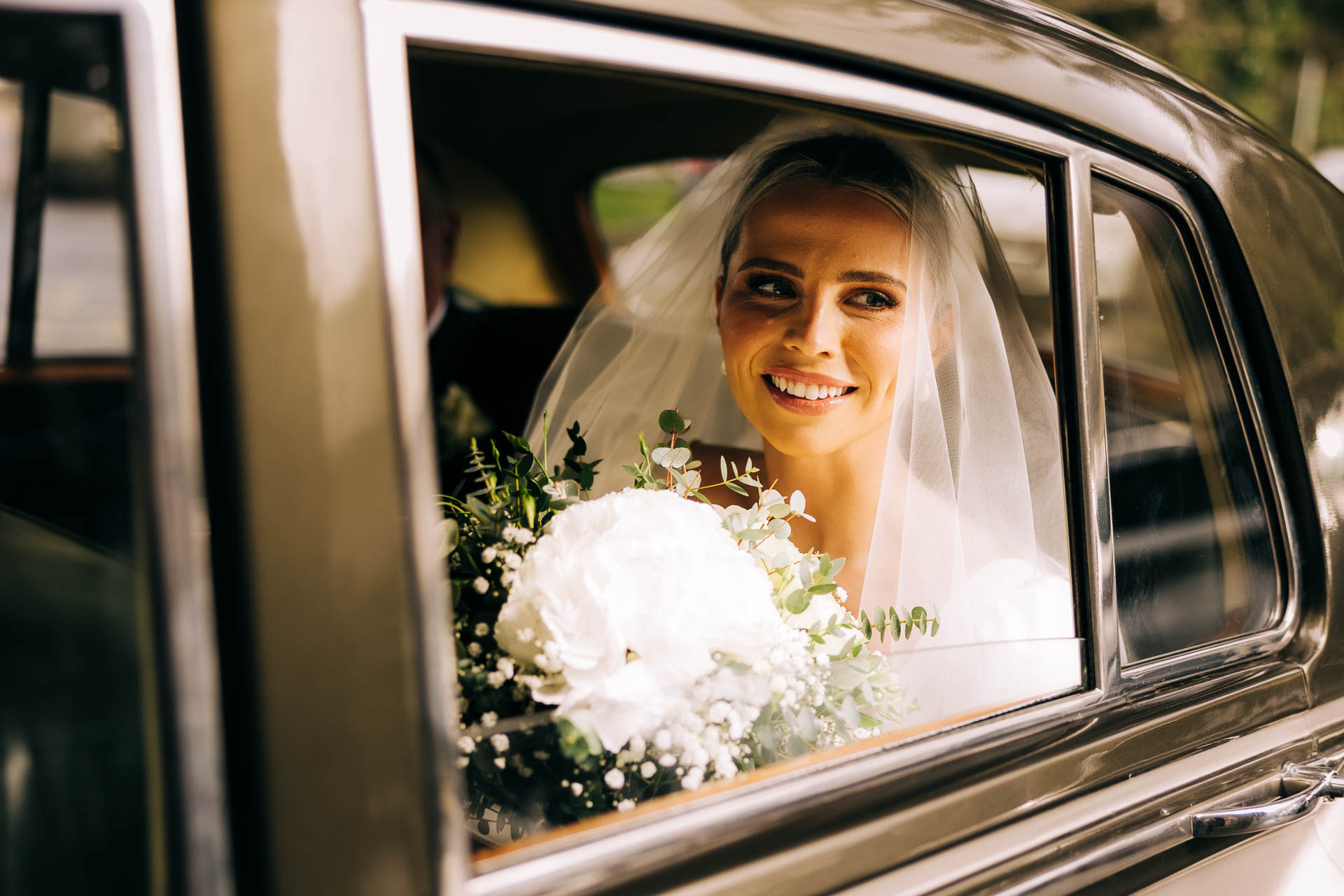 Bride sitting in the wedding car