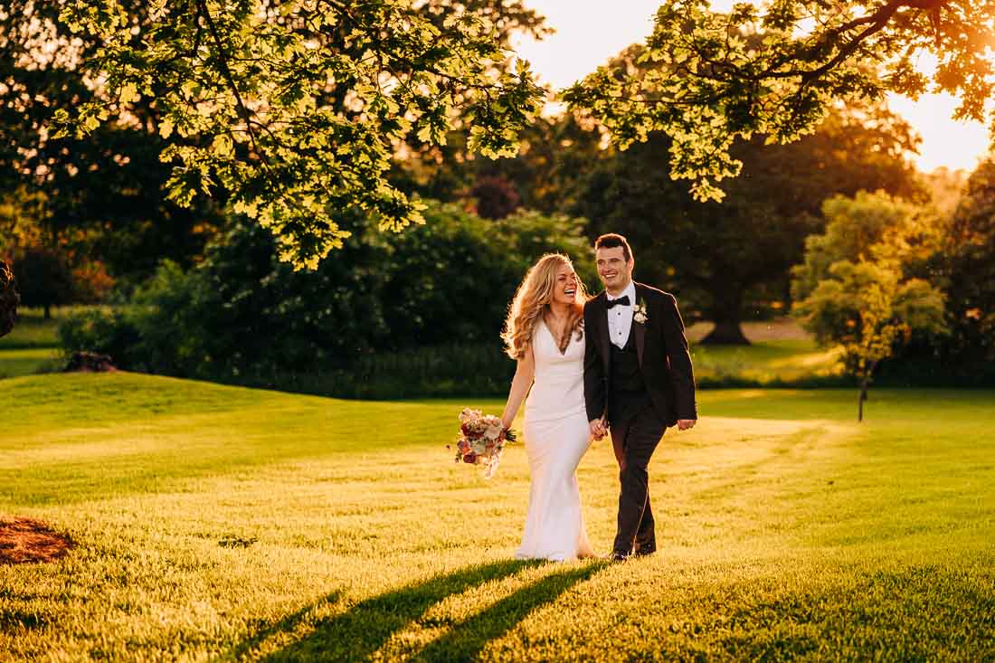 A married couple walk hand in hand at sunset in rathsallagh house