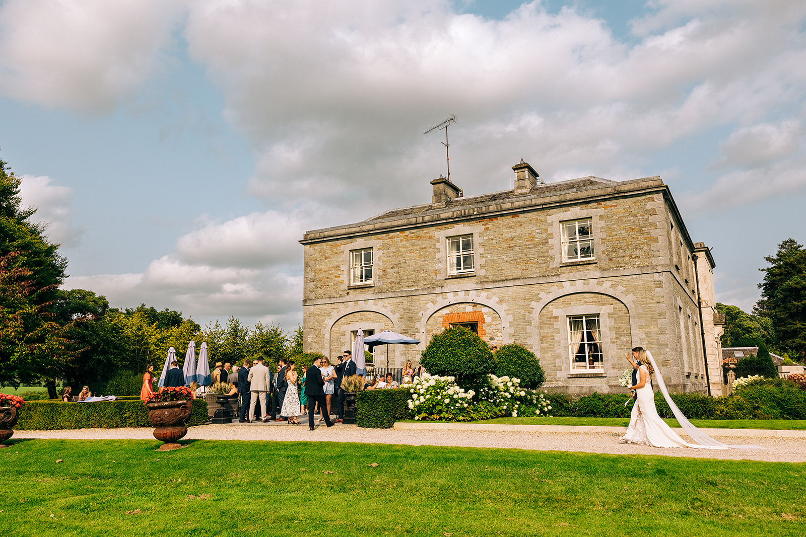 Sadhbh & Andrew | Tankardstown House bride and groom with Tankardstown House and their wedding guest in the background