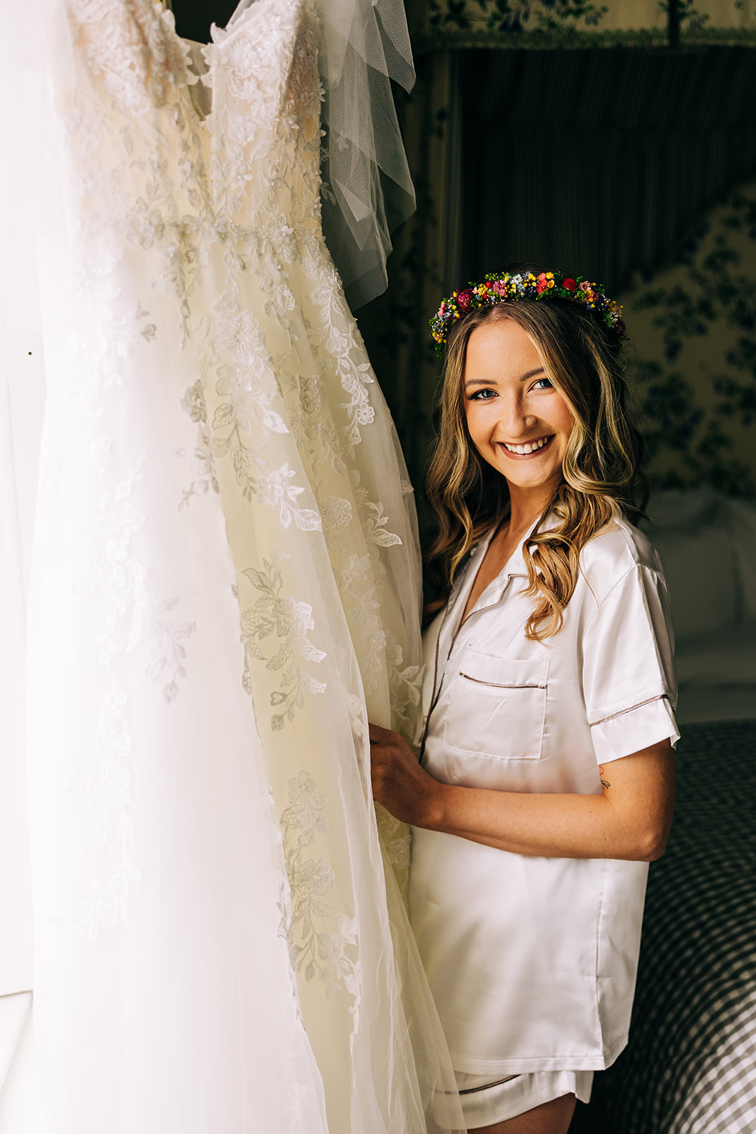 Magdalena & Ronan | Martinstown House bride in satin pyjamas smiling while holding her wedding dress getting ready at Martinstown House Kildare