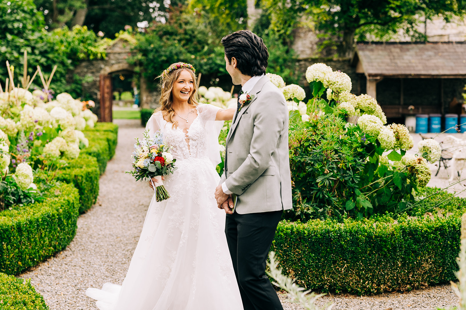 Magdalena & Ronan | Martinstown House bride and groom laughing together in the walled garden at Martinstown House surrounded by hydrangeas