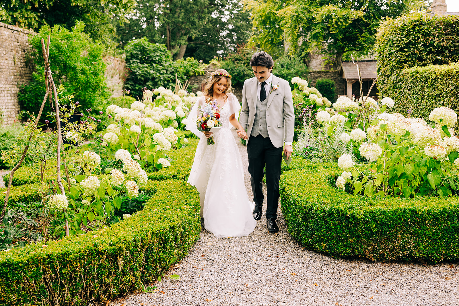Magdalena & Ronan | Martinstown House bride and groom walking hand in hand through the formal walled garden at Martinstown House Co Kildare